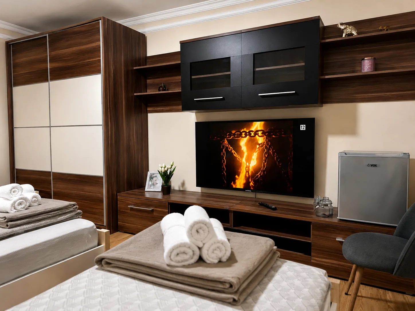 Royal Apartmani Negotin — spavaća soba sa TV zidom, garderoberom i uredno složenim peškirima